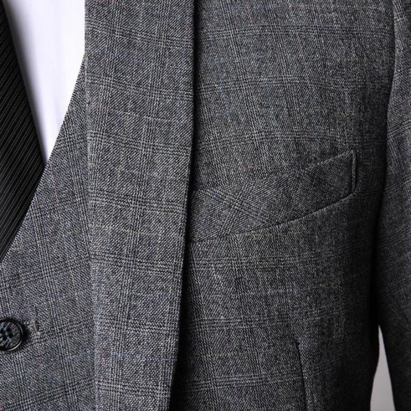 Grey tweed suit jacket showing herringbone fabric and chest pocket detail